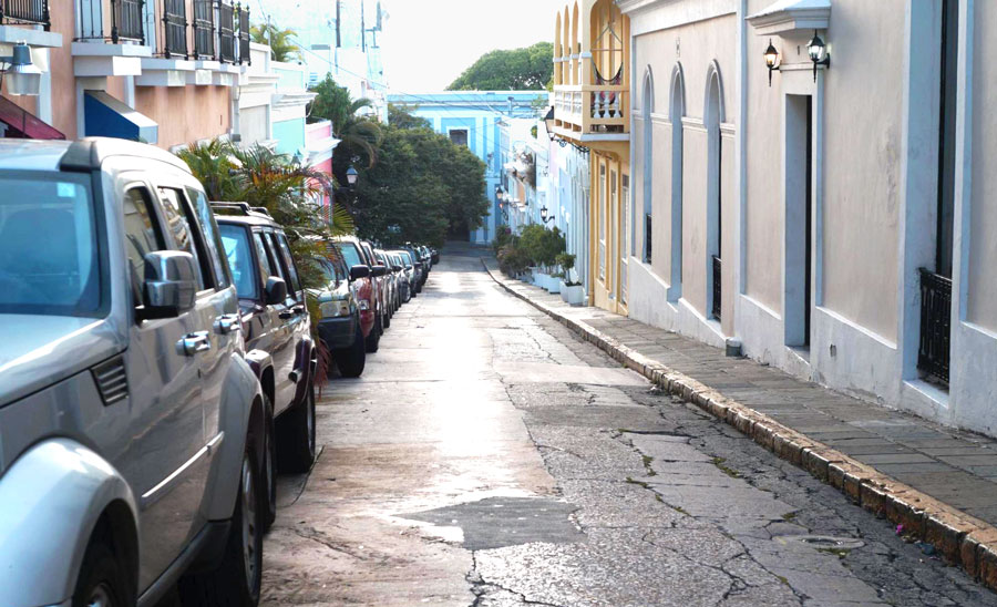 View of the cars parked in an alley with colorful houses
