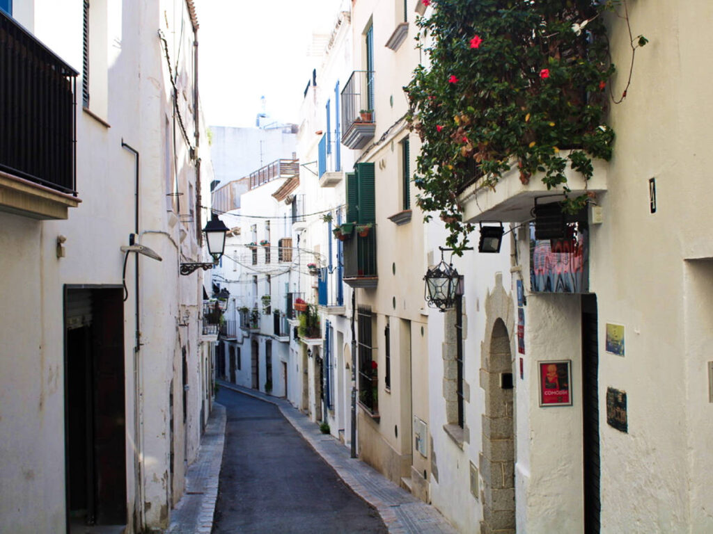 View of the narrow alleyway surrounded by white buildings in Sitges