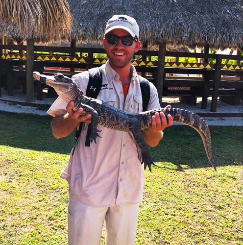View of the author holding a small alligator