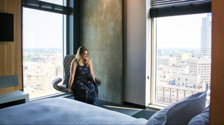 The author Taylor Herperger, looking at Downtown Winnipeg from the Alt Hotel suite room
