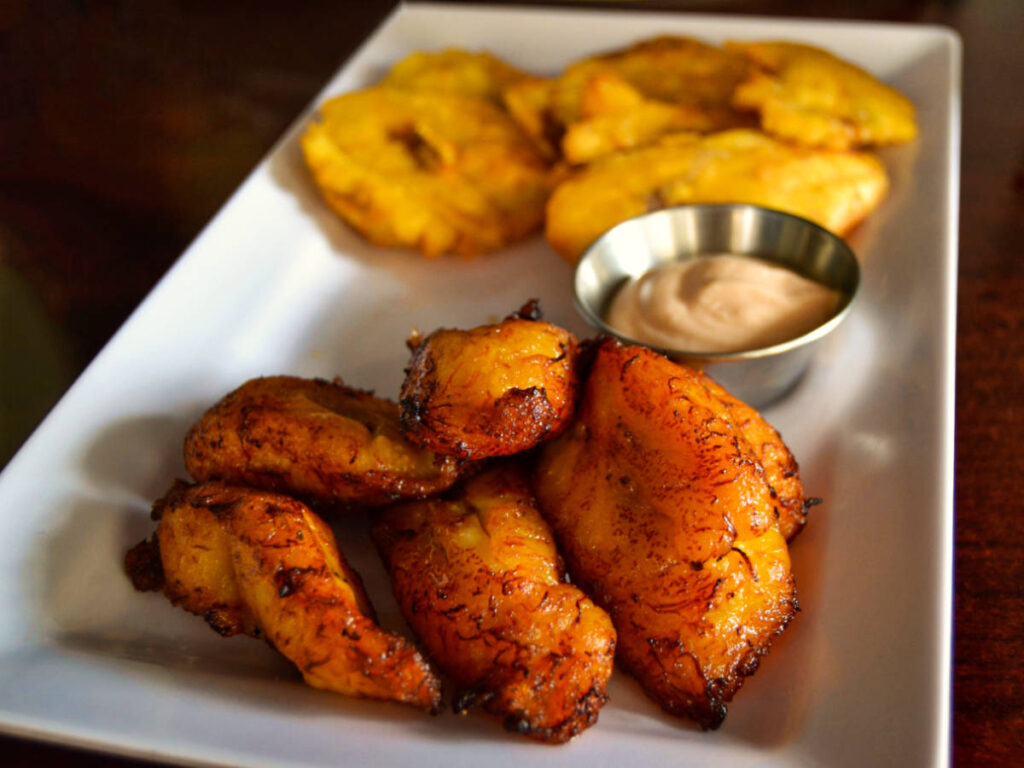 Closeup look of a fried banana with dipping sauce on a plate