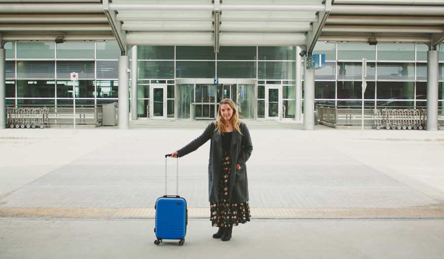 The author holding her Amazon Basics Luggage