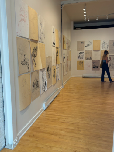 A woman looking at the drawings in the art pop-up