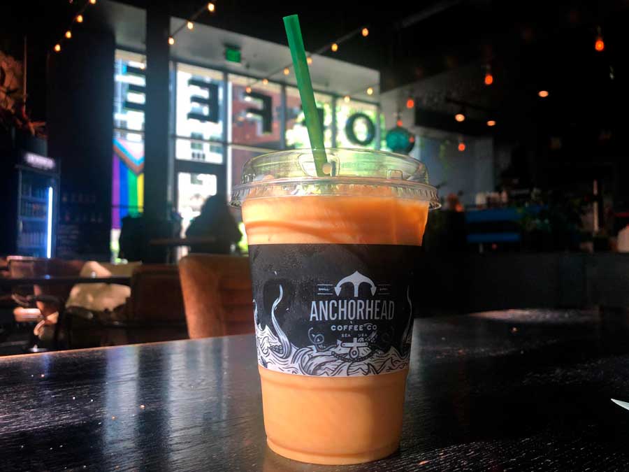 A cup of coffee with straw on a table in Anchorhead Coffee
