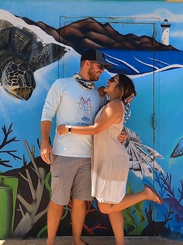 Andrew with her wife posing for a photo in Rincon, Puerto Rico