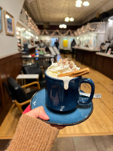 A hand holding a cup of Animas Chocolate drink