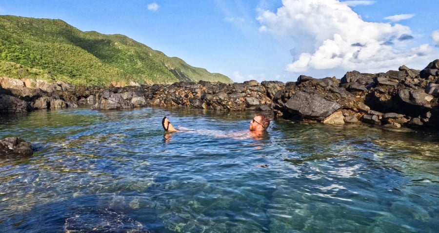 A man floating in the middle of tide pools on the North Shore of St. Croix