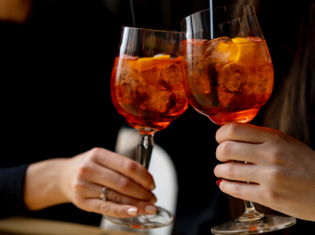 Friends toasting with aperol spritz cocktails