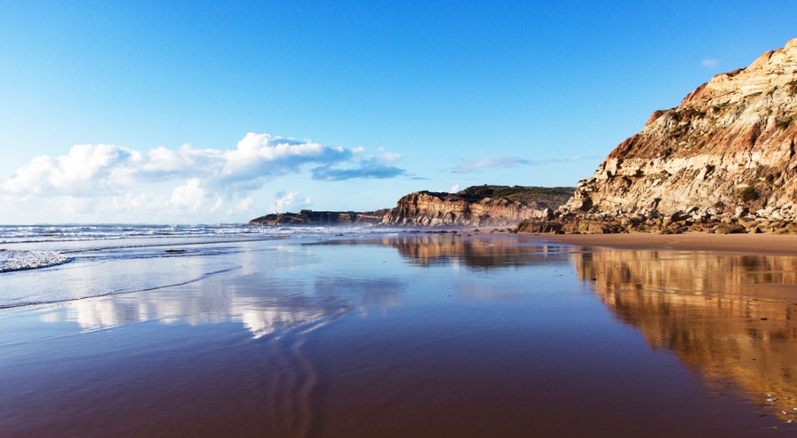 View of the mountain reflected on the smooth water of Areia Branca beach