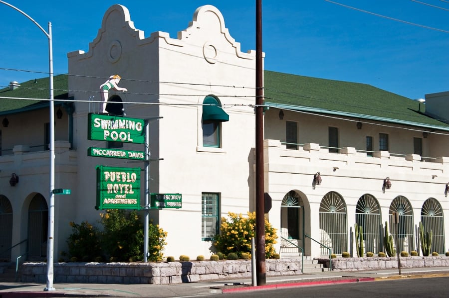 Exterior view of the Pueblo Hotel and Apartments with signages at the corner