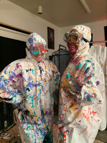 Jess Levy and friend covered in paint, after an art session activity at Studio Interactive