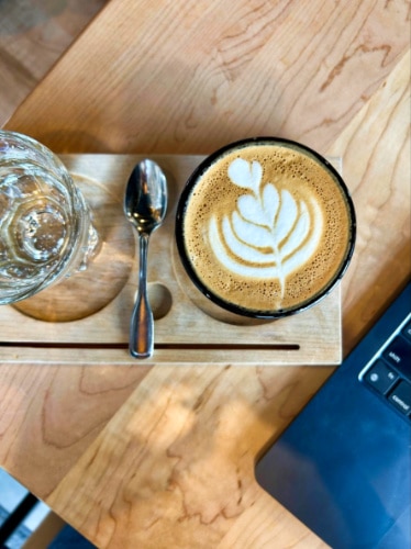 Top view of a glass of Cortado with a latte art