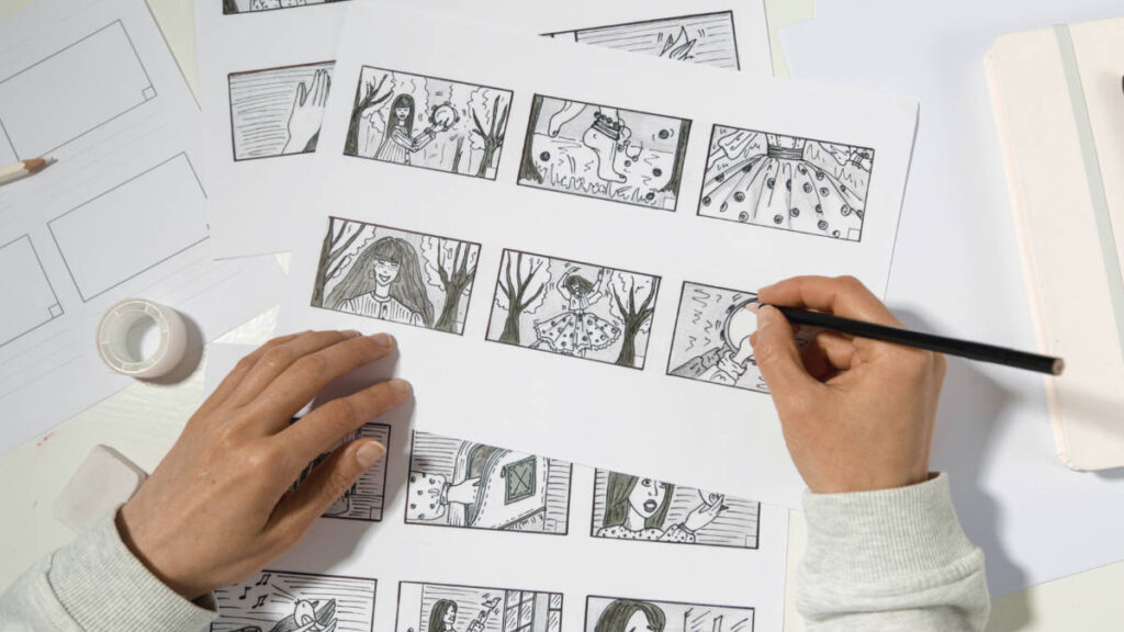 An artist's hands drawing a cartoon storyboard with a pencil