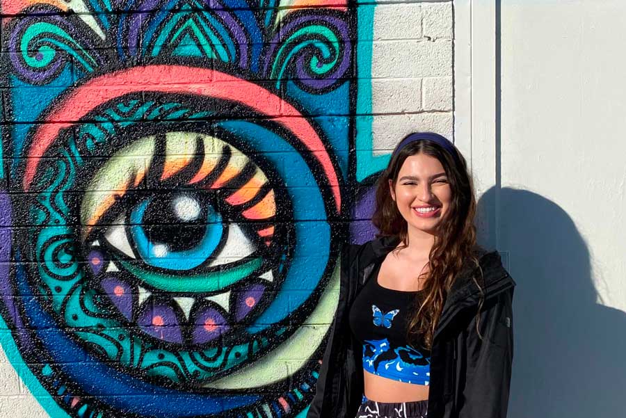 The author posing for a photo with one of the murals in Arts District