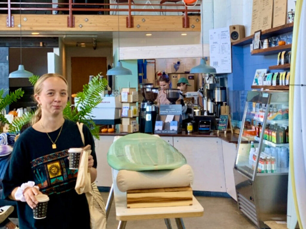 A woman holding cup of coffees at Andytown Coffee Roasters