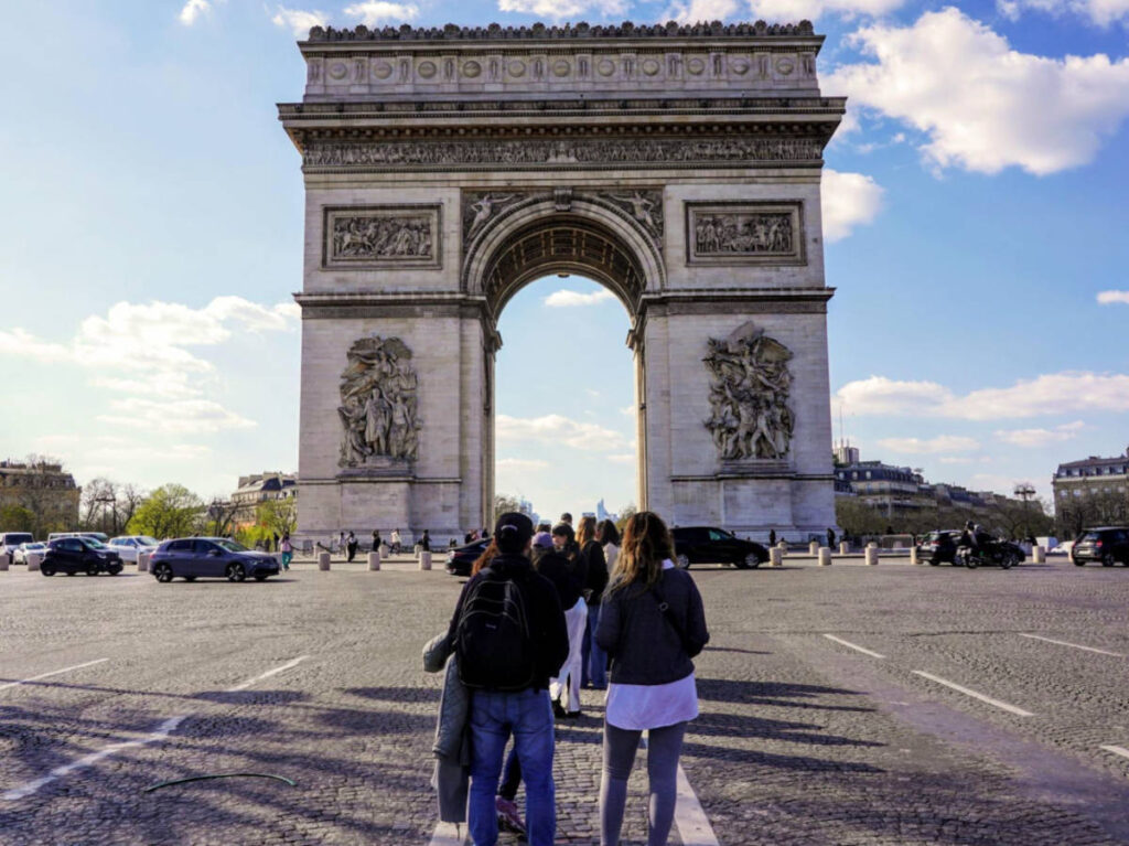 Group of tourists waiting to take photos at the Arc de Triomphe