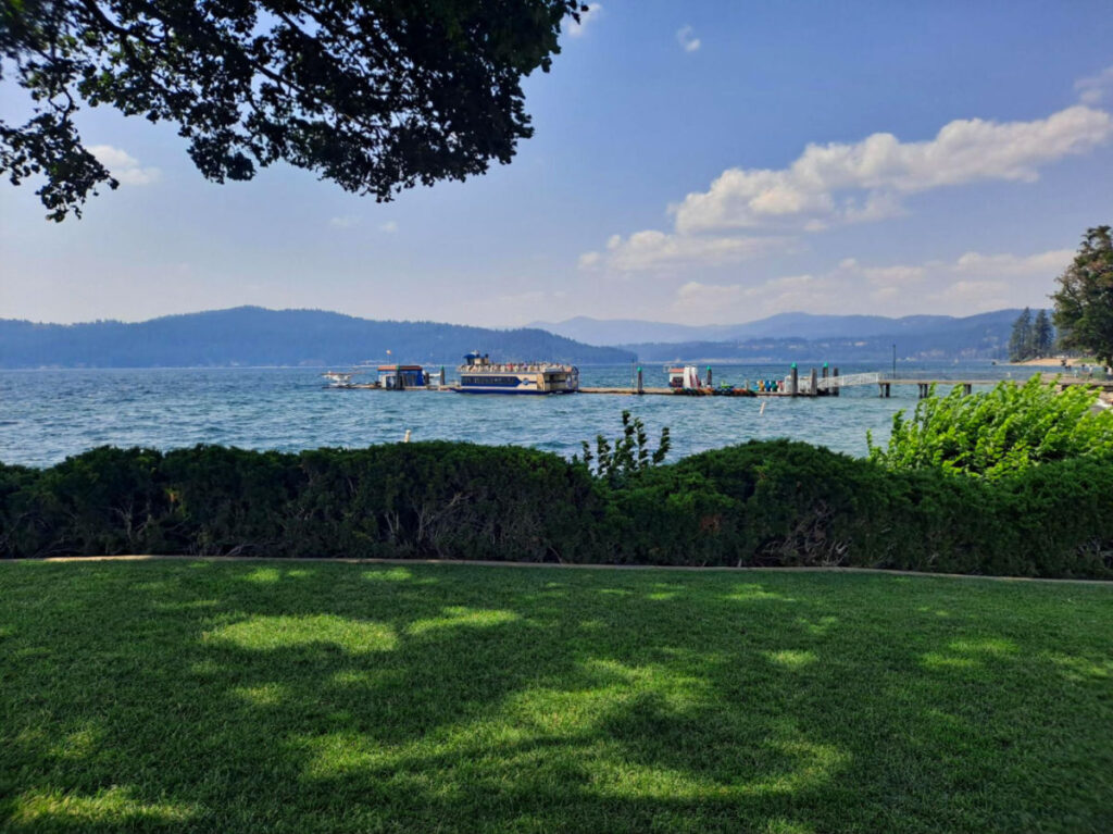View of Coeur d’Alene's water and mountains from a green lawn
