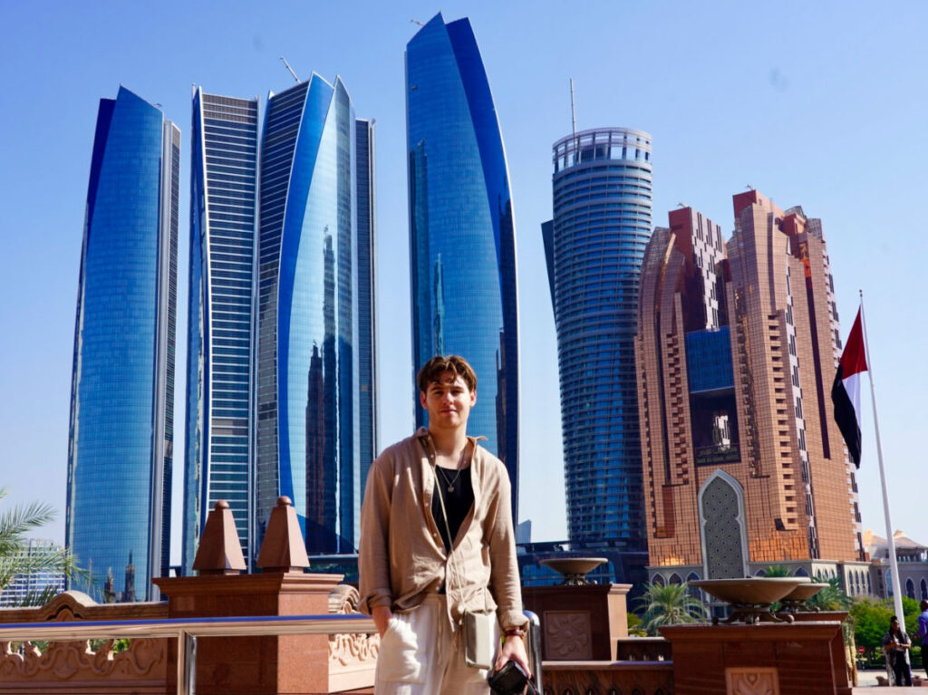 Author's boyfriend posing for photo with the Downtown Abu Dhabi buildings