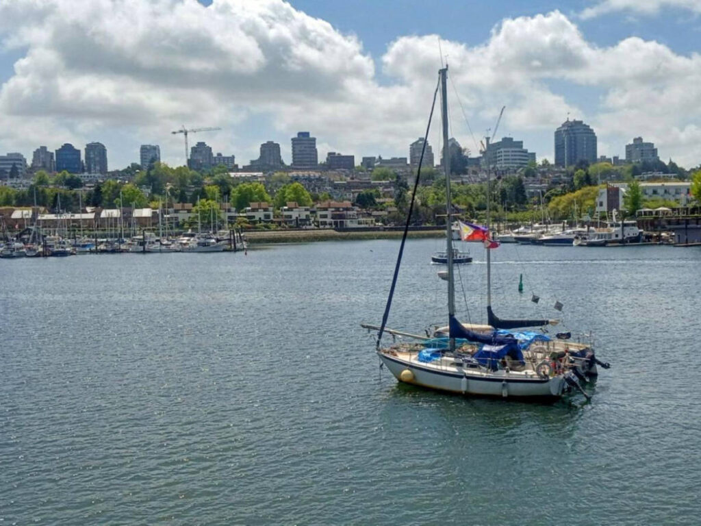 A sailboat in False Creek, surrounded by the cityscape of Vancouver