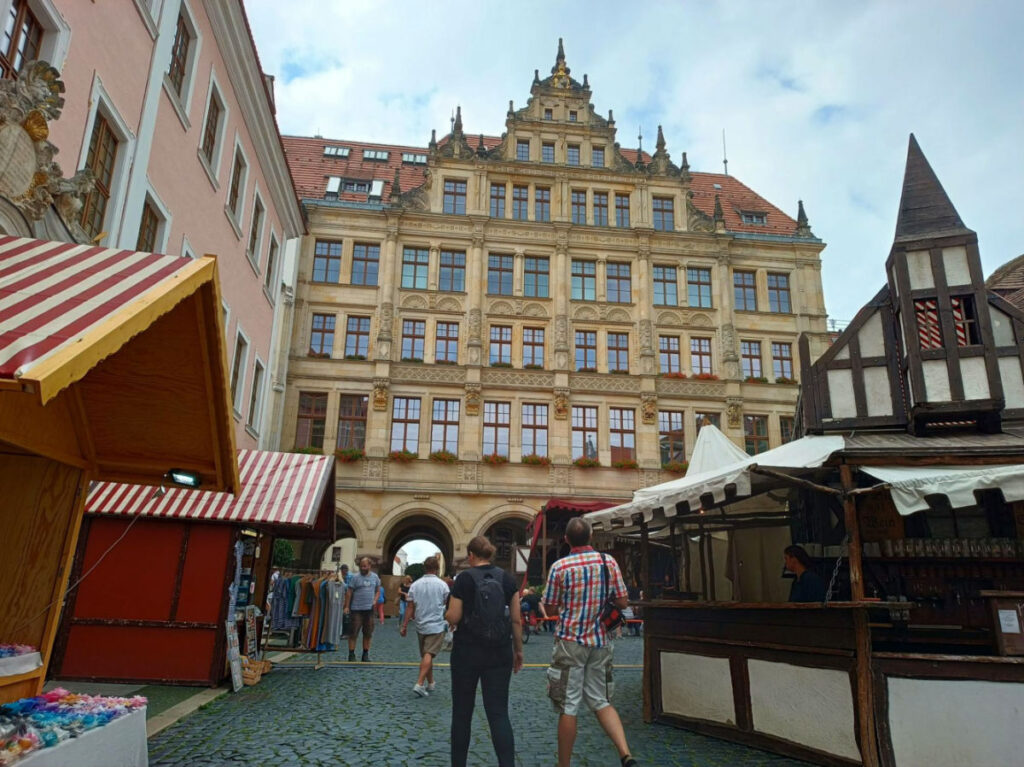 People strolling on a cobblestone street in front of a building in Görlitz