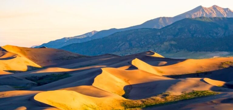 View of sand dunes against mountains at Great Sand Dunes National Park