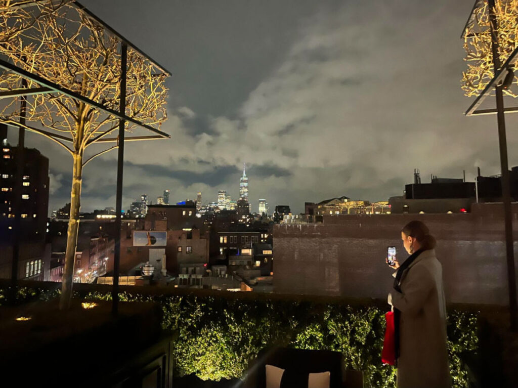 A woman taking a photo of the skyline at RH Rooftop