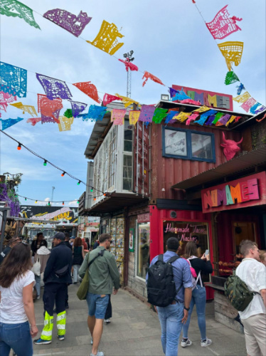 People walking through Reffen Food Market with colorful flags hanging