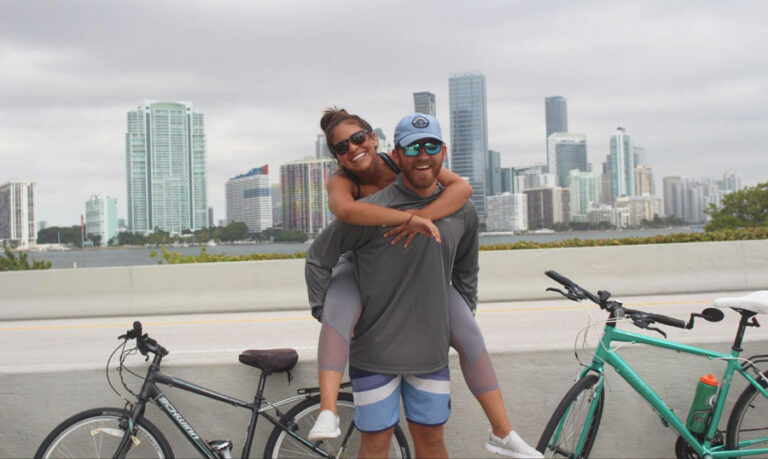 The author and her wife posing for a picture in William Powell Bridge with their bike on their background