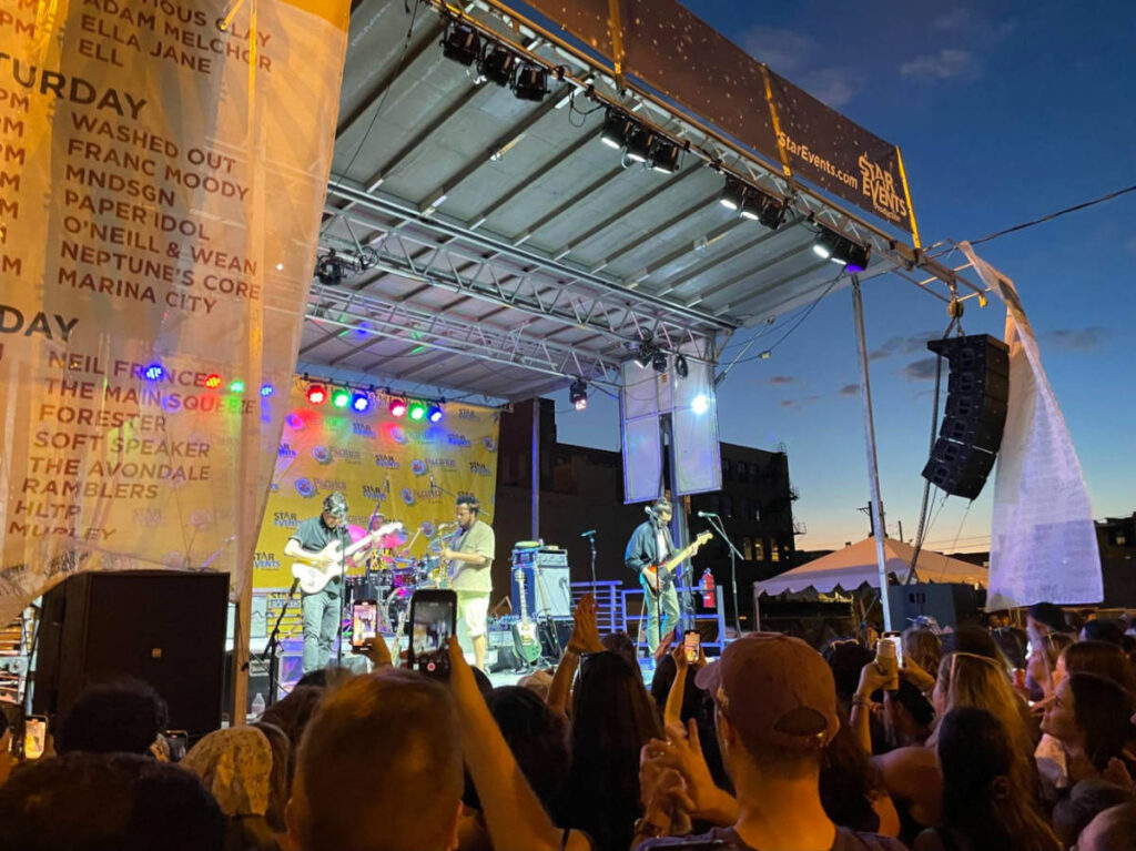 A band performing while the crowd watches them at Taste of Randolph