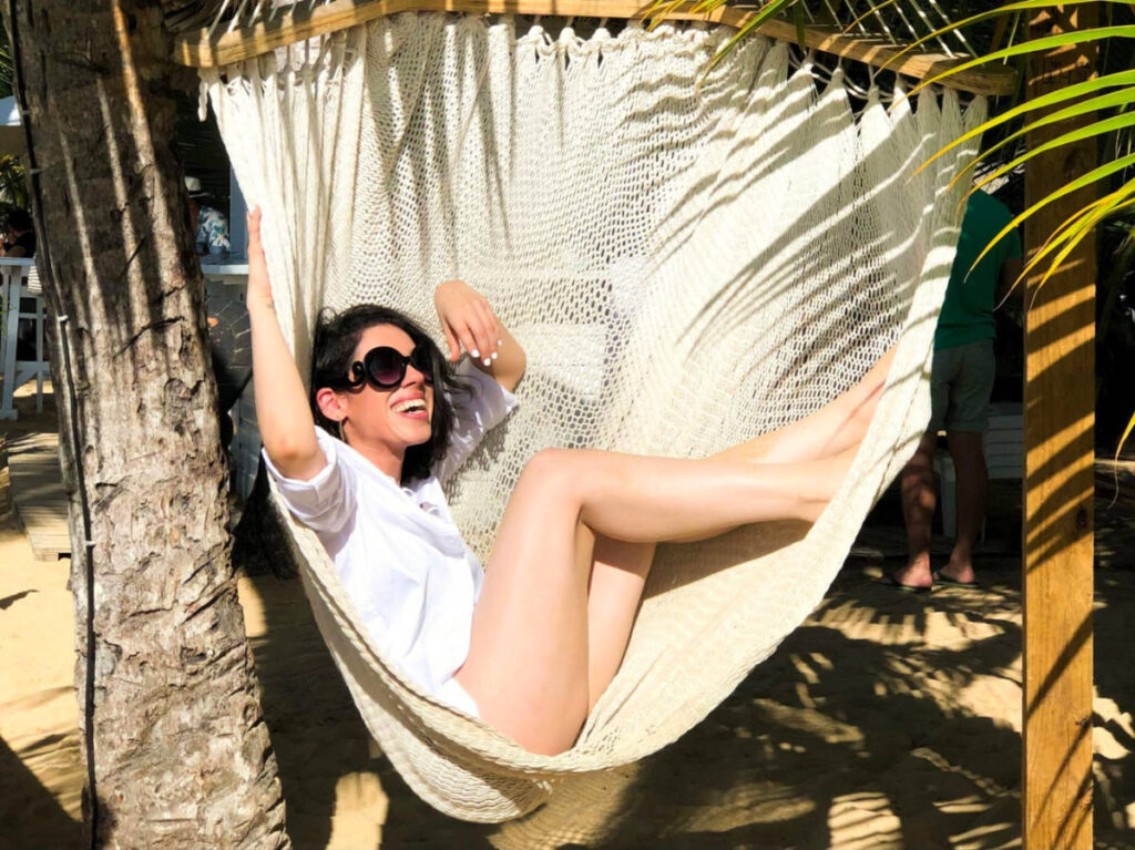 Author Claudicet Pena in sunglasses relaxing in a hammock at Las Terrenas beach