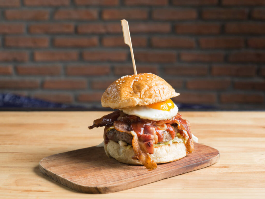 A Au Cheval cheeseburger on a wooden tray