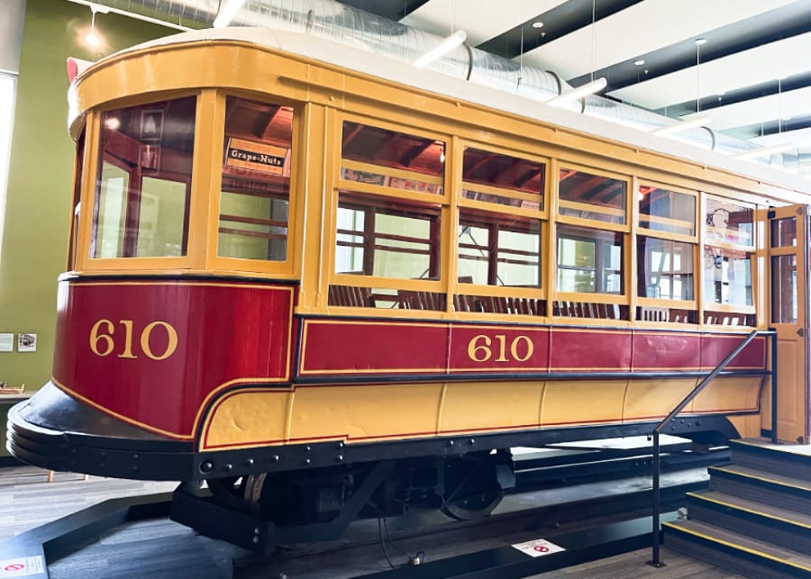 A yellow and red vintage trolley in Aurora History Museum