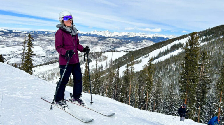 The author Abigail Bliss, posing at the summit with scenic mountain views at Beaver Creek