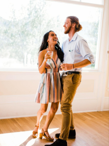 Author Abigail and her husband holding a glass of wine during their wedding at The Stanley Hotel