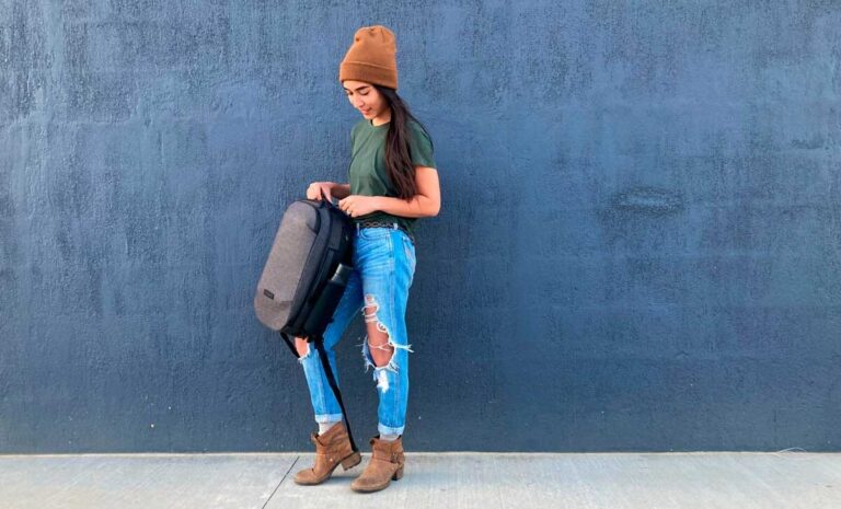 The author Abigail holding and unzipping her Backpack