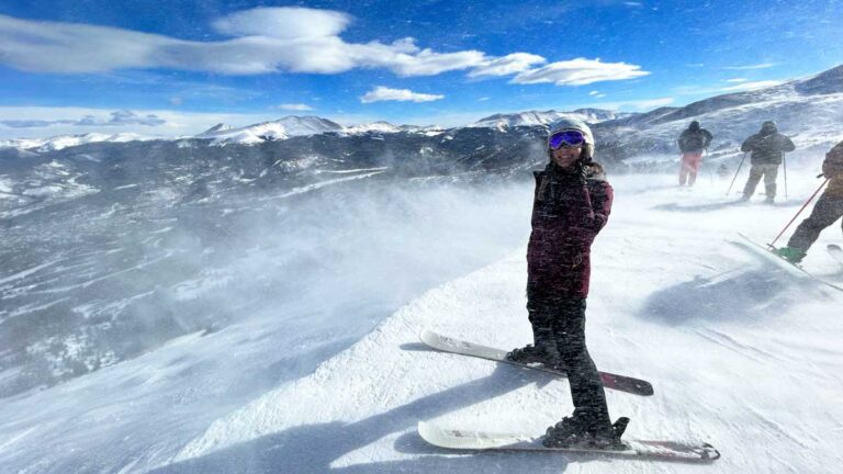 The author Abigail Bliss smiling while wearing her ski gear on a snowy slope at Breckenridge
