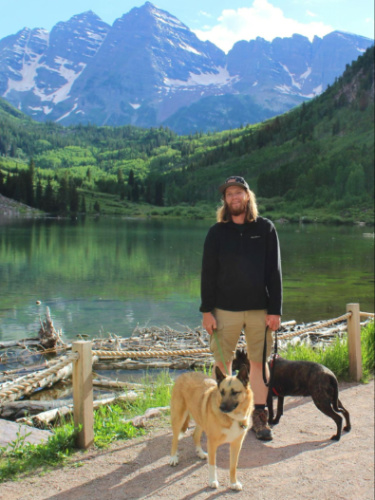 Author Abigail's husband and their dogs at Cathedral Lake with the Maroon Bells in the background