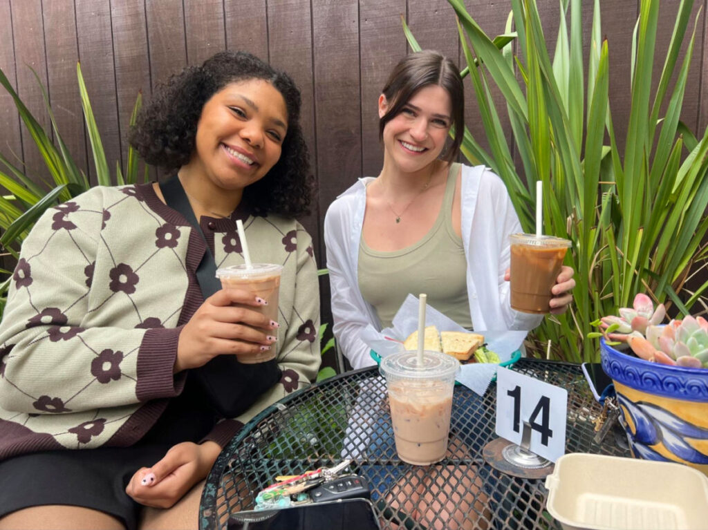 Author Betty and her roommate holding a cup of coffee at Progressive Grounds