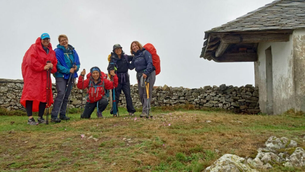 Author Catherine and other hikers in front of the walls and a little church of an old hospital