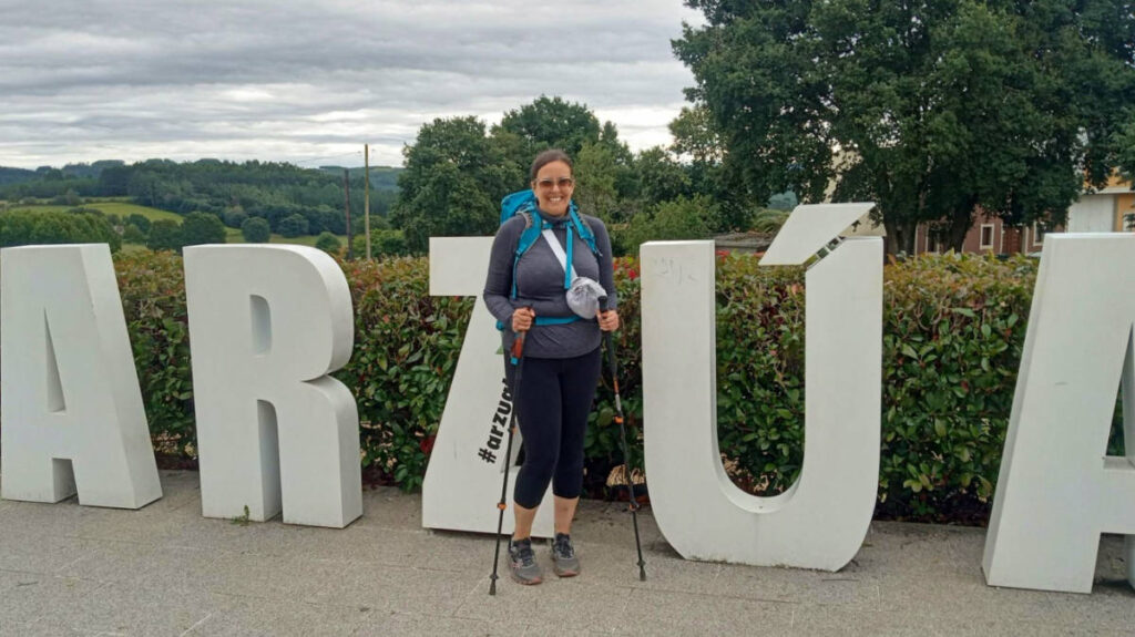 Author Catherine posing for a photo with the Arzúa sign