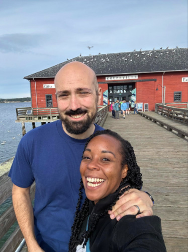Author Chelsea and her husband smiling for a selfie at Coupeville Wharf