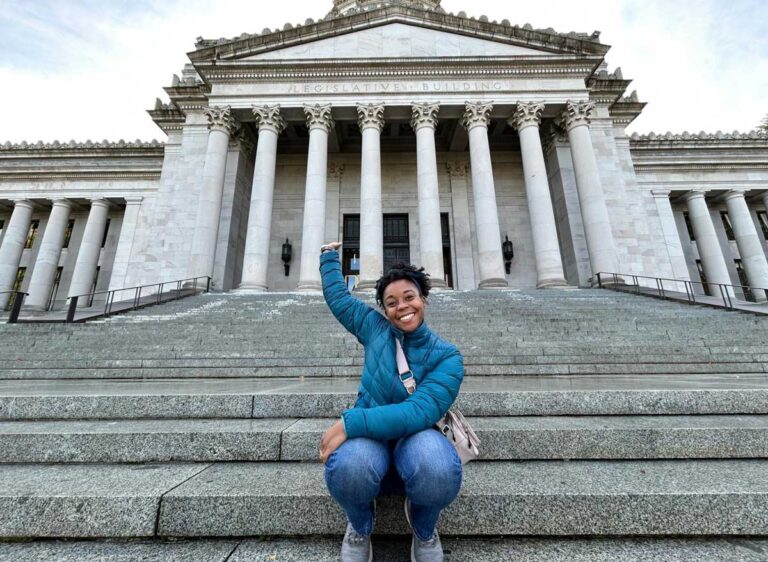 The author Chelsea Booker sitting in front of the Washington State Capitol Building