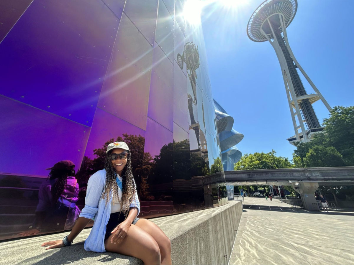 Author Chelsea sitting next to the MoPOP with the Space Needle in the background