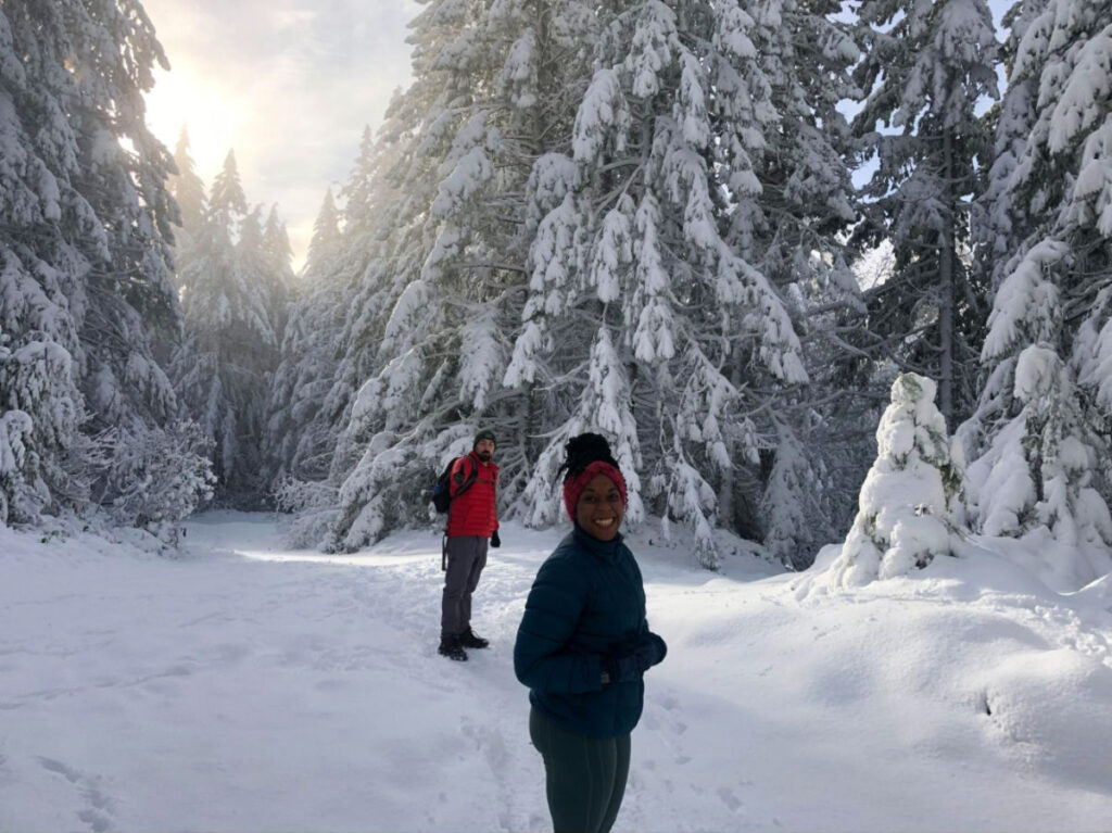 Author Chelsea and her husband hiking through a snowy forest