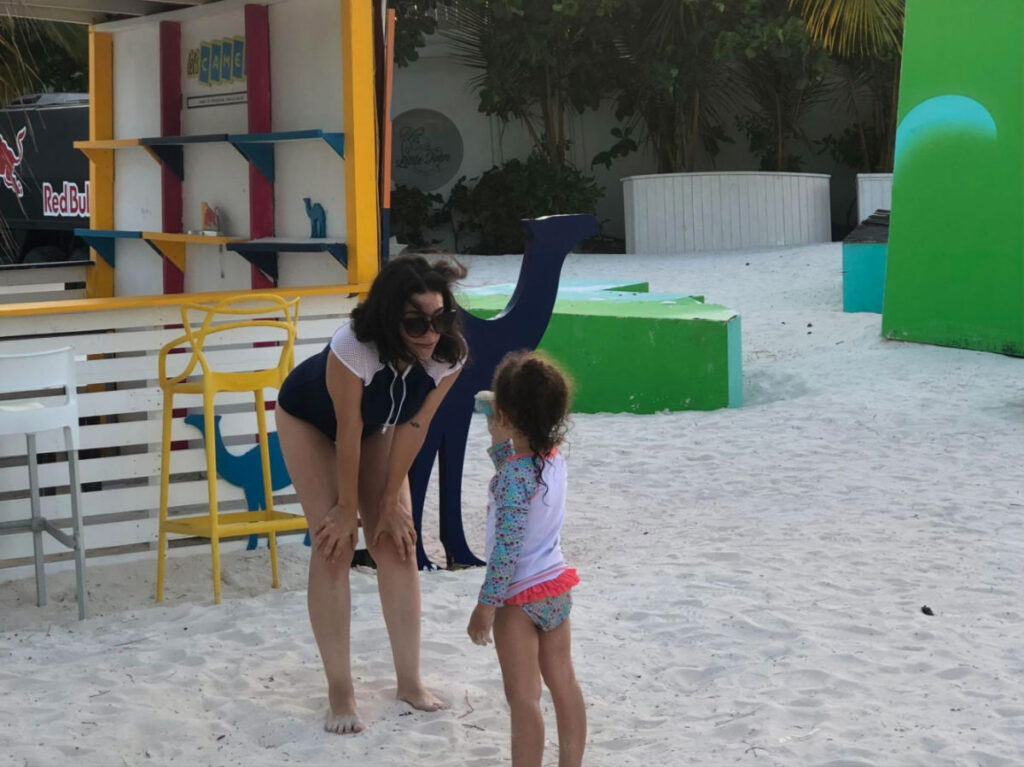 Author Claudicet looking at her daughter near Little John Restaurant at Playa Juanillo
