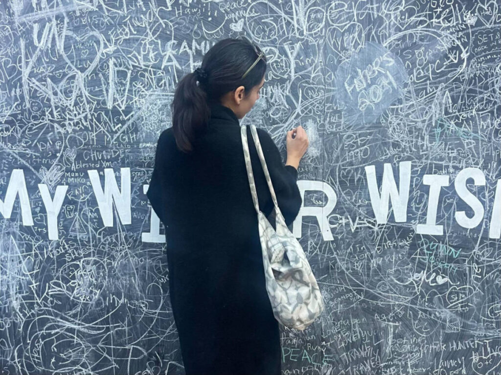 Author Claudicet writing on a wall at Seaport’s Snowport Market