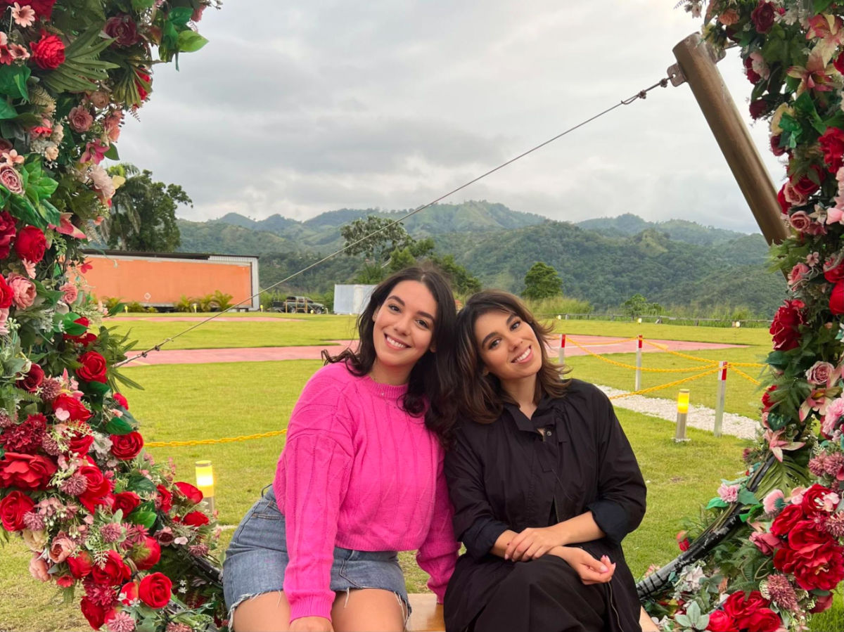 Author Claudicet and her sister posing for a photo in flower themed photo spot with mountain views in Jarabacoa