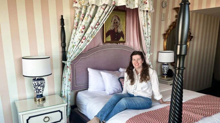 The author Elizabeth Demolat sitting on the bed of Graduate Hotel room