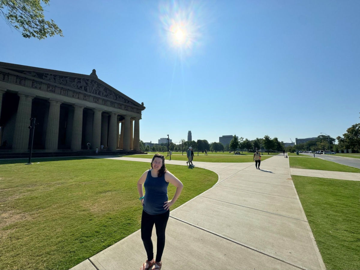 Author Elizabeth in front of the Parthenon in Centennial Park on a sunny day