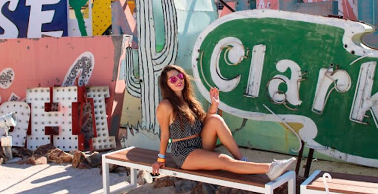 The author Isabelle Pavese posing for a photo with the old neon signs at the Neon Museum